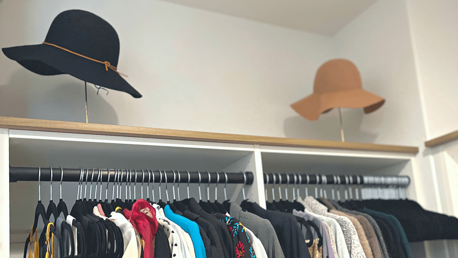 closet showing 2 gold hat stands with hats