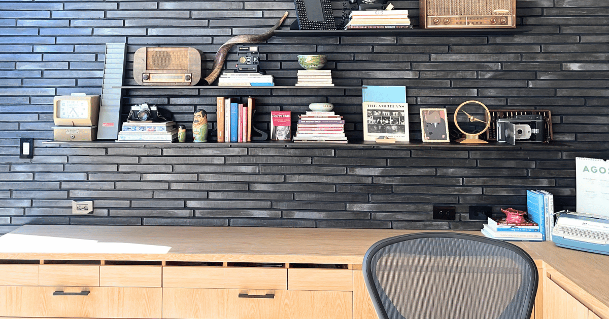A beautifully organized home office with curated floating shelves and a clean oak desk, by luxury home organizer Melinda Grace in Santa Monica.